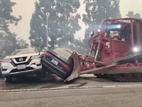 Des voitures déplacées au bulldozer pour libérer la route de l'incendie de Pacific Palisades